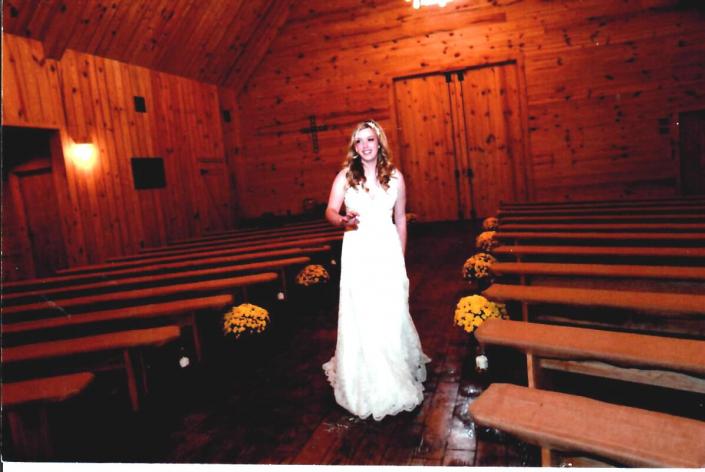 This beautiful bride stands before our venue surrounded by our long benches that can seat between 150-200 guests! 